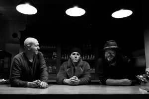 Die drei Musiker sitzen an einem Tisch